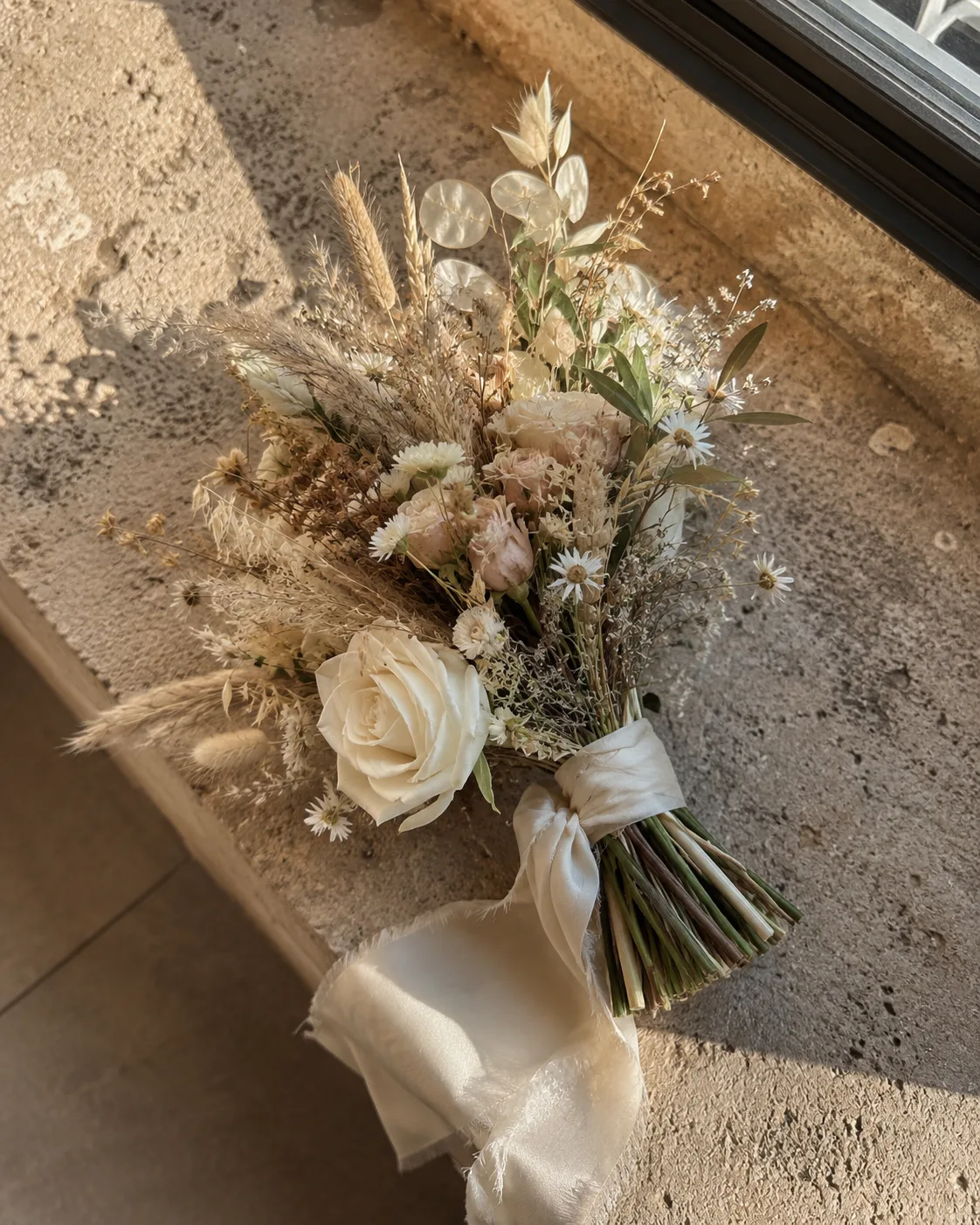 Bouquet de mariée bohème posé sur pierre