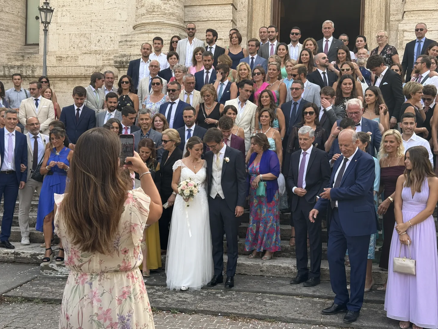Photo de groupe des mariés devant l'église